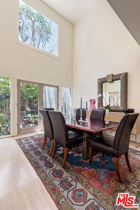 dining area with hardwood / wood-style flooring and a high ceiling