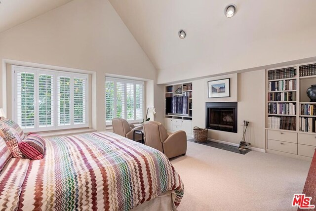 bedroom with carpet flooring and high vaulted ceiling