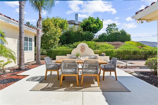 view of patio featuring outdoor dining space and fence