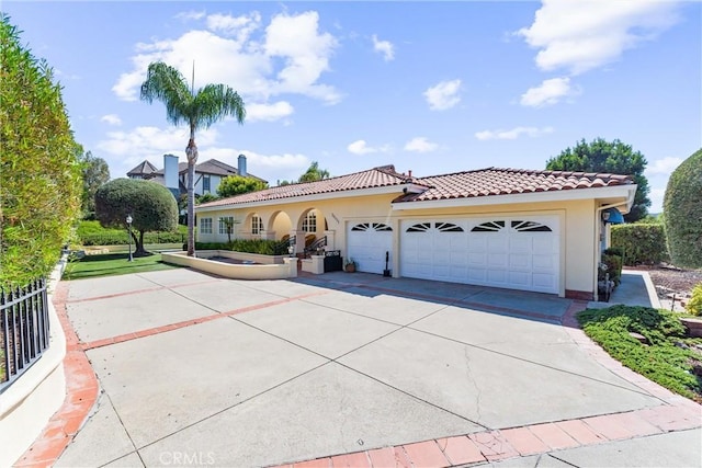 mediterranean / spanish house with stucco siding, concrete driveway, and a tiled roof