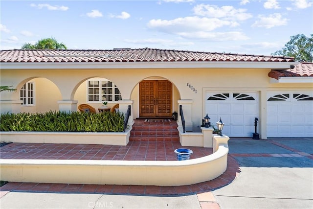 mediterranean / spanish-style home with stucco siding, driveway, and an attached garage