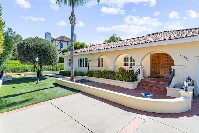 exterior space with stucco siding, french doors, a tile roof, and a yard