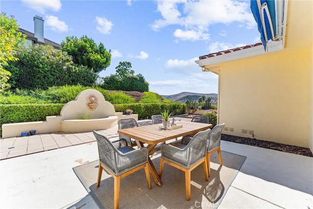 view of patio featuring outdoor dining area and a mountain view