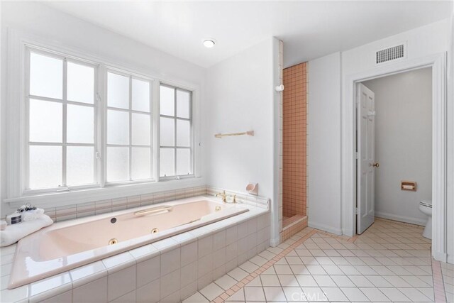 bathroom featuring toilet, a healthy amount of sunlight, shower with separate bathtub, and tile patterned floors