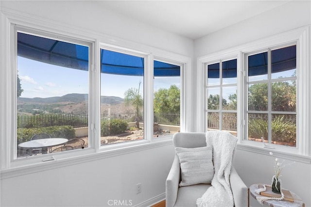 sunroom / solarium featuring a healthy amount of sunlight and a mountain view