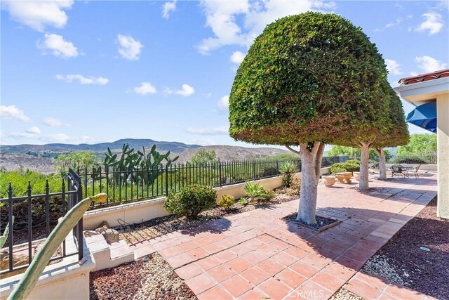 view of patio / terrace featuring fence private yard and a mountain view