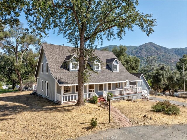 cape cod home with a mountain view and a porch