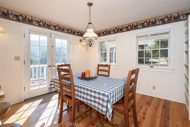 dining space featuring a notable chandelier, french doors, and hardwood / wood-style flooring