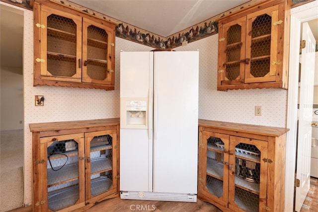 kitchen featuring white fridge with ice dispenser and hardwood / wood-style flooring