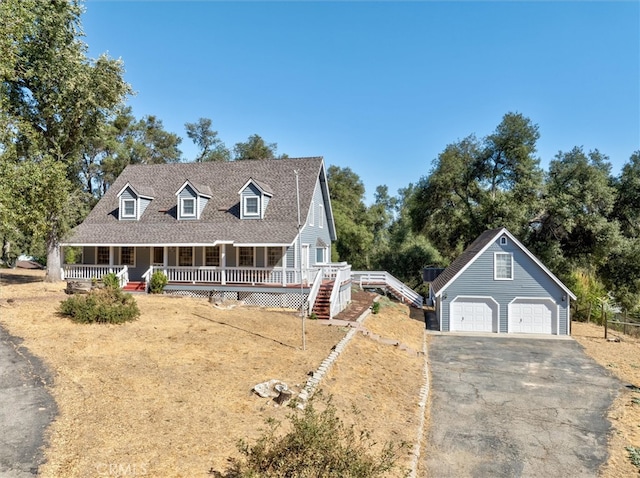 cape cod house featuring an outdoor structure, a porch, and a garage