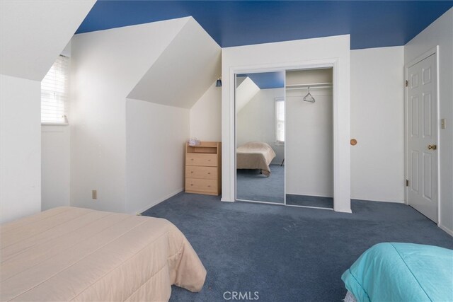 carpeted bedroom with vaulted ceiling and a closet