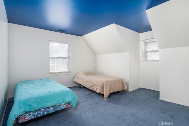 bedroom with dark carpet and vaulted ceiling