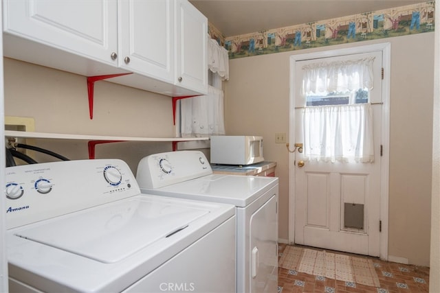 laundry area featuring washer and dryer and cabinets