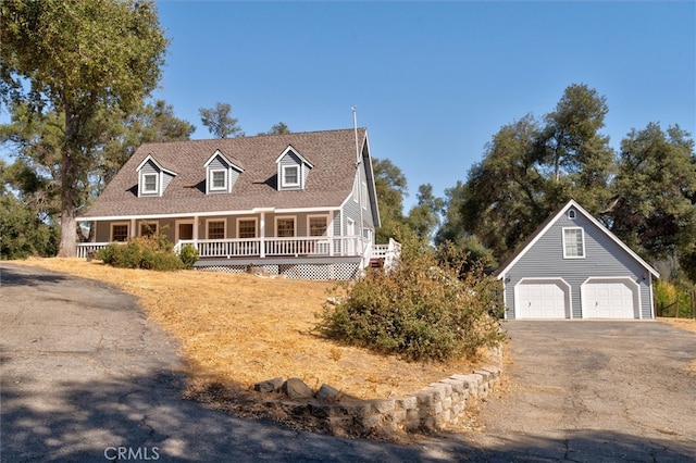 cape cod-style house featuring an outbuilding, a porch, and a garage