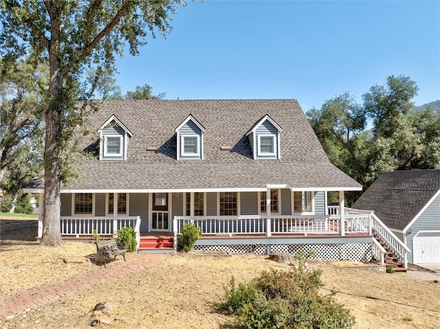 cape cod house with a garage and a porch