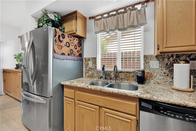 kitchen featuring light tile patterned flooring, sink, tasteful backsplash, stainless steel appliances, and light stone countertops