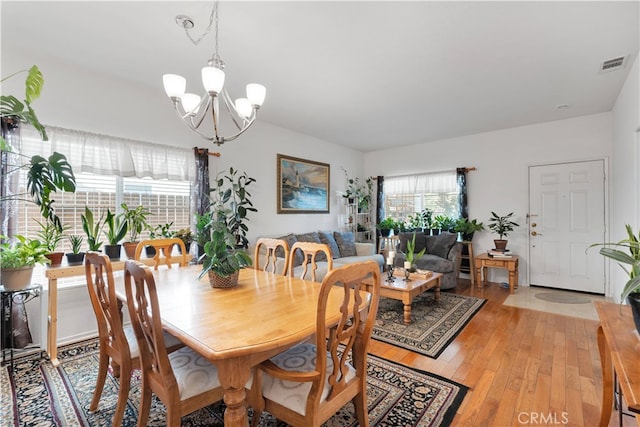 dining space with a chandelier and light hardwood / wood-style floors