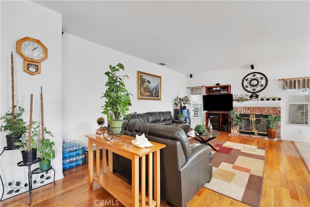 living room with hardwood / wood-style flooring and a fireplace