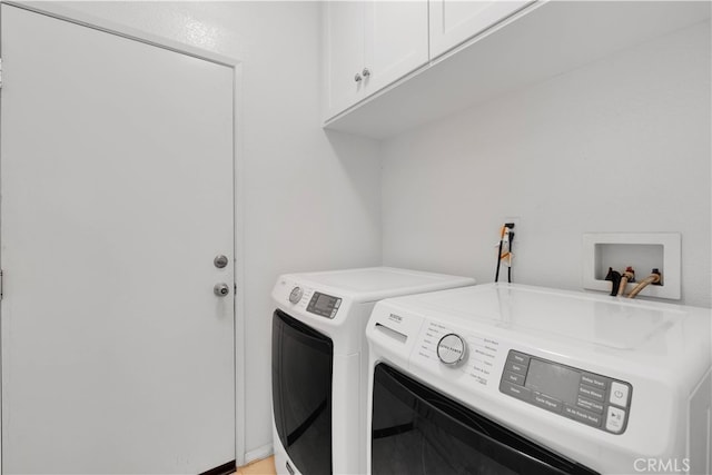 laundry room featuring cabinets and washer and dryer