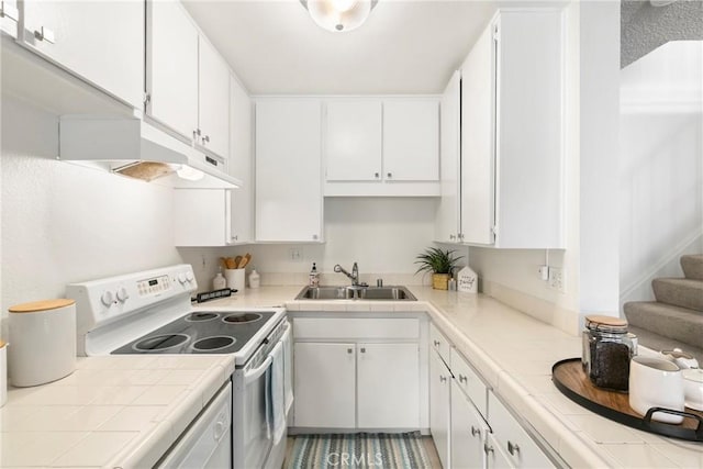 kitchen featuring tile countertops, white electric range, white cabinetry, and sink