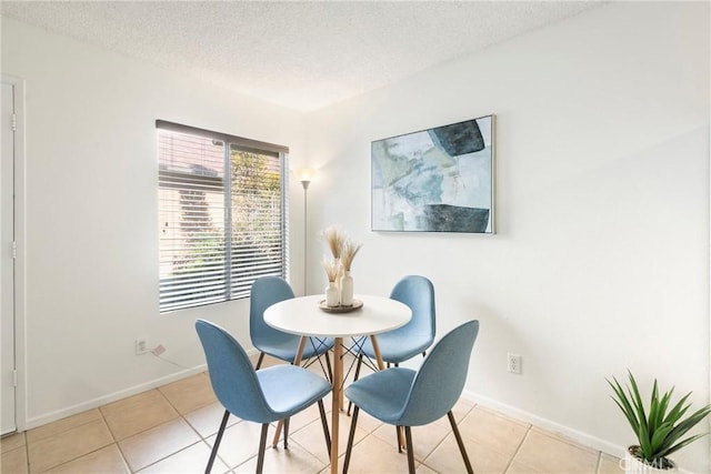 tiled dining room with a textured ceiling