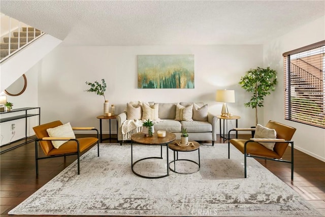 living room featuring a textured ceiling and dark hardwood / wood-style floors