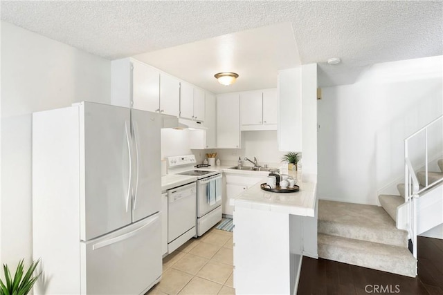 kitchen with a textured ceiling, white appliances, white cabinetry, and sink