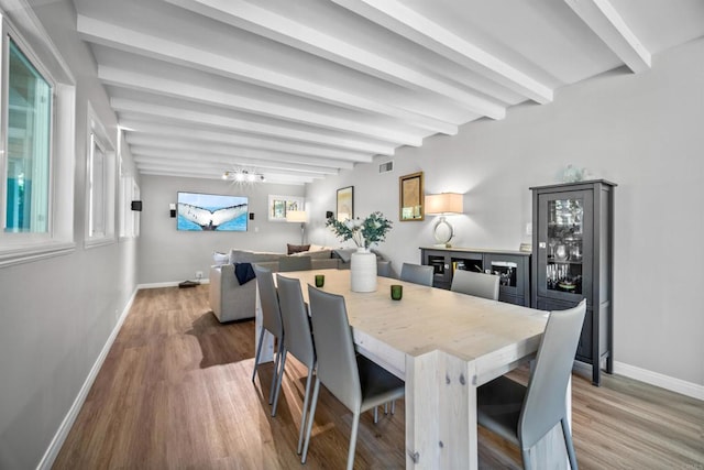 dining room featuring beam ceiling and wood-type flooring