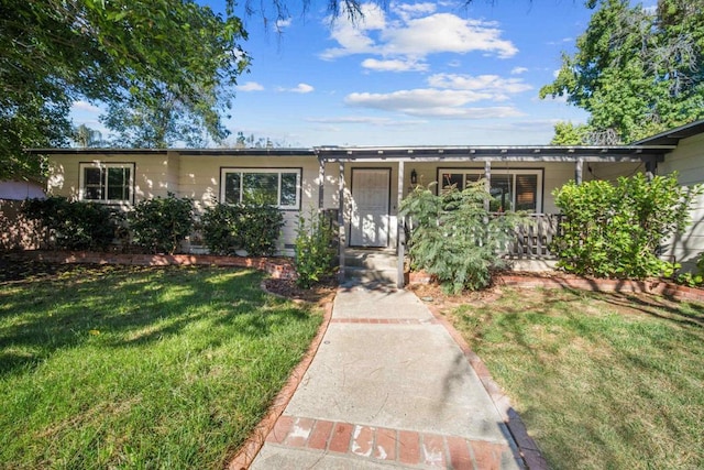 single story home with covered porch and a front yard