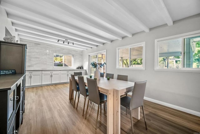 dining space with plenty of natural light, beam ceiling, and light wood-type flooring