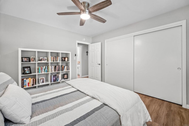 bedroom with ceiling fan, a closet, and wood-type flooring