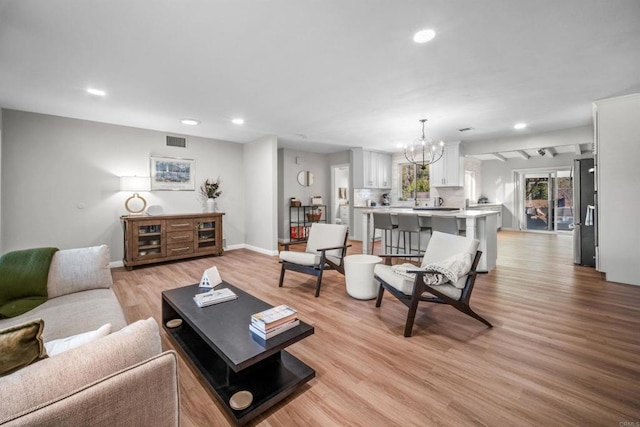 living room featuring light hardwood / wood-style floors and a chandelier