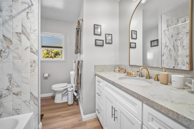 full bathroom with hardwood / wood-style floors, vanity, toilet, and tiled shower / bath combo