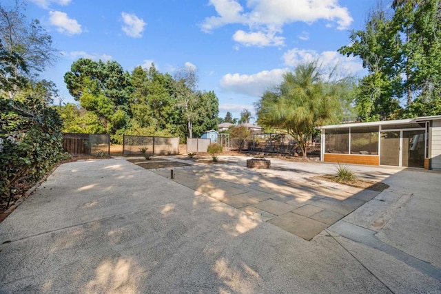 view of patio featuring a sunroom and a fire pit