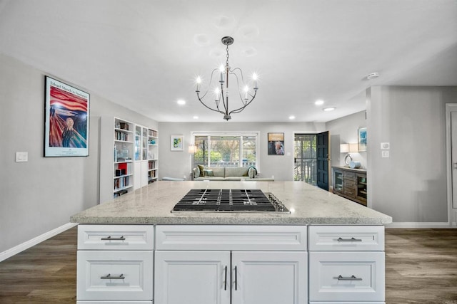 kitchen with pendant lighting, white cabinets, dark wood-type flooring, and stainless steel gas cooktop