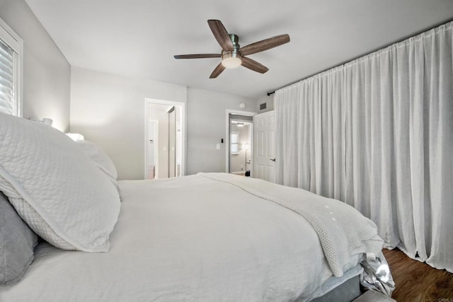 bedroom with ensuite bath, ceiling fan, and wood-type flooring