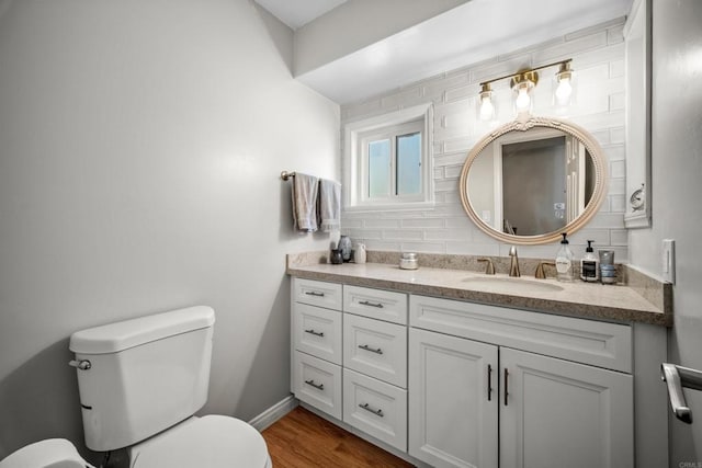 bathroom featuring decorative backsplash, hardwood / wood-style floors, vanity, and toilet