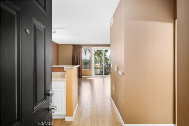 corridor with light hardwood / wood-style floors