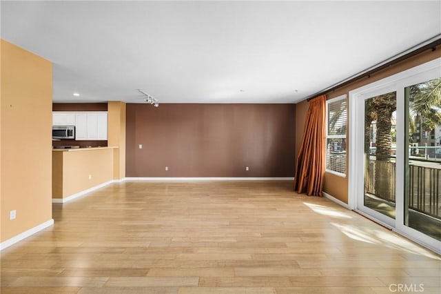 unfurnished living room featuring light wood-type flooring, baseboards, and recessed lighting