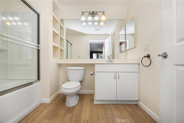 full bathroom featuring wood-type flooring, bath / shower combo with glass door, toilet, and vanity