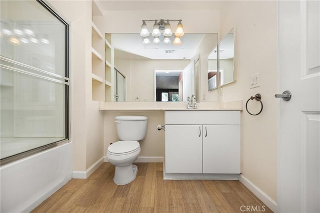 bathroom with toilet, baseboards, wood finished floors, and vanity