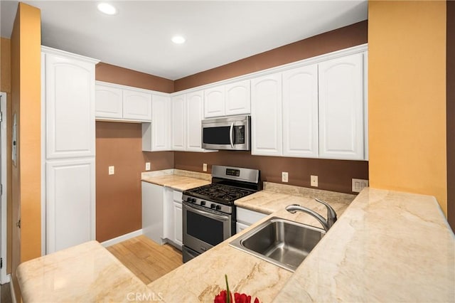 kitchen featuring white cabinets, light wood-type flooring, sink, and stainless steel appliances