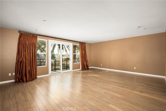 empty room with baseboards and light wood finished floors