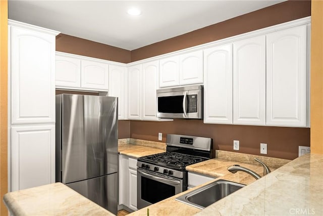 kitchen featuring stainless steel appliances, recessed lighting, a sink, and white cabinets