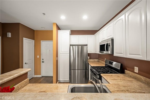 kitchen with white cabinetry, appliances with stainless steel finishes, and a sink