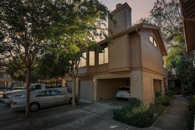 property exterior at dusk featuring a garage