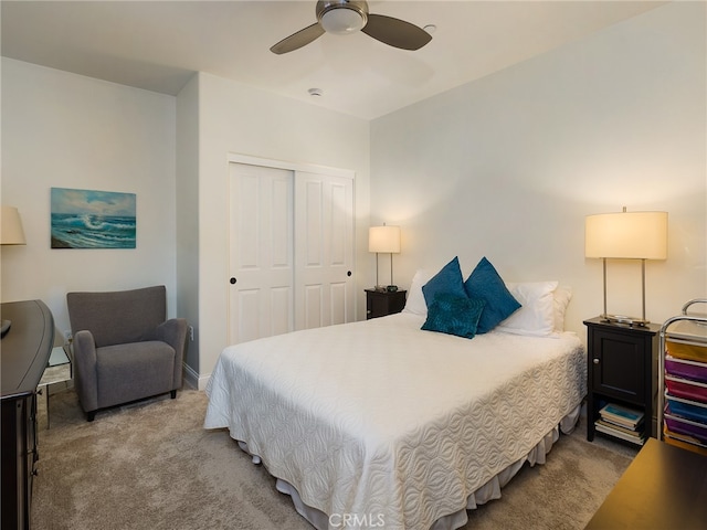 carpeted bedroom with ceiling fan and a closet