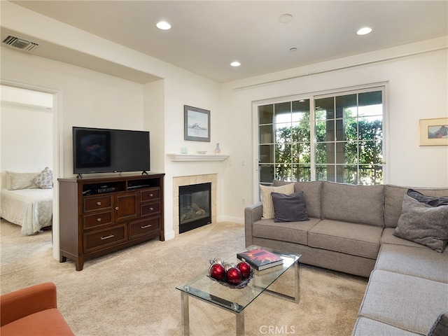 carpeted living room with a tile fireplace