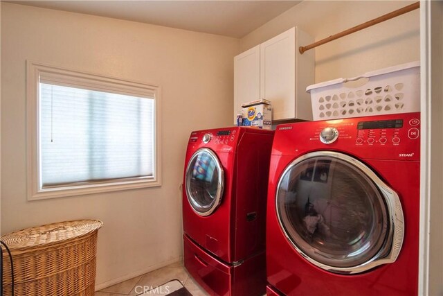 laundry room featuring cabinets, light tile patterned floors, and washing machine and clothes dryer