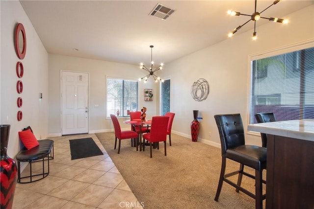 tiled dining room featuring an inviting chandelier